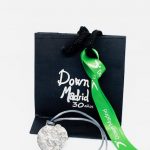 Embalaje y colgante de plata conmemorativo de Down Madrid